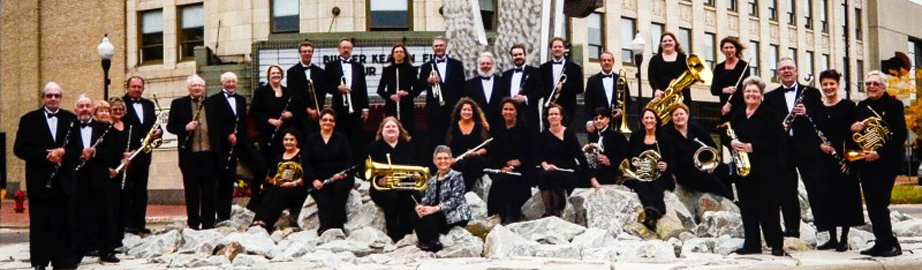 Band members with instruments in front of Fruaenthal on the rocks where sculpture is in circle